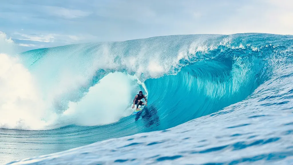 Wide view of a surfer on a big turquoise wave